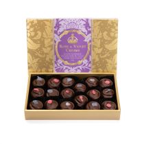 A box of Rose & Violet Creams with gold embossed Acanthus packaging and a purple band with "Rose & Violet Creams: Luxury Handmade English Rose & Violet Cream Chocolates." 