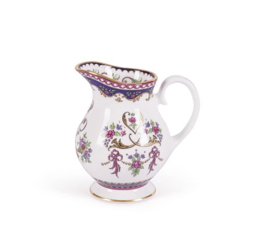 Queen Victoria fine bone china cream jug with a design featuring Queen Victoria's name cipher surrounded by floral patterns and gold plated rims.