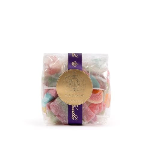 A transparent packet of sweets in multiple colours with purple Windsor Castle ribbon and circular gold label