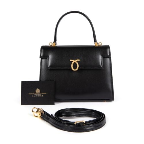 A black leather handbag with top handle and gold coloured clasp