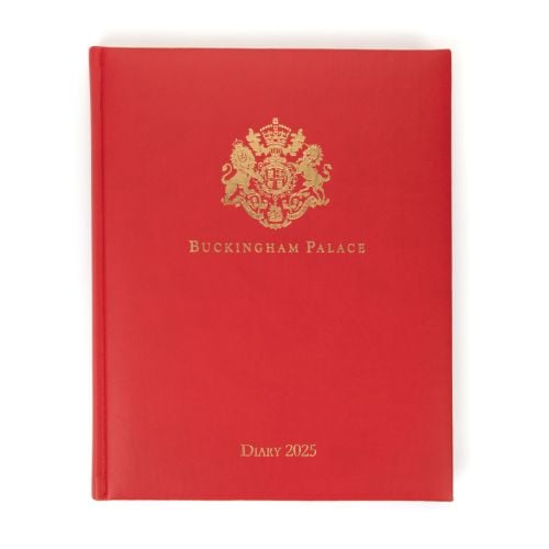 Red desk diary with gold embossed crest and lettering, Buckingham Palace Diary 2025.