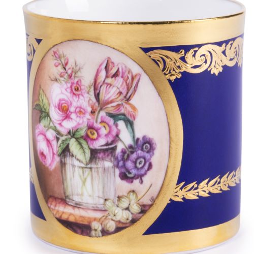 The Prestige Vase of Flowers Gobelet Litron, featuring central oval shape with hand painted bouquet of pink and purple flowers in a wooden pot. The rest of the teacup and saucer has a rich cobalt blue paint and is finished with 22 carat gold gilding along