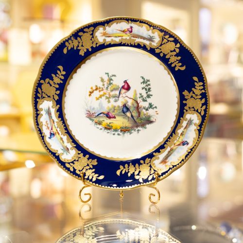 Image of the Prestige Sevres Cobalt Plate on stand, featuring three exotic birds at centre and cobalt blue edging with detailing. 