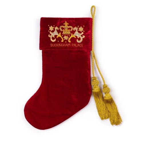 A red velvet stocking with a gold tassle and Buckingham Palace Emblem. 