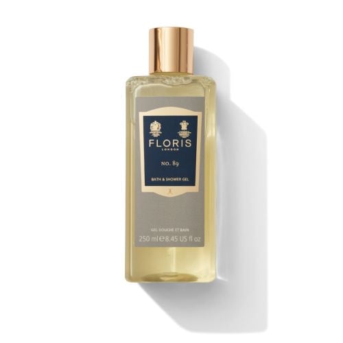 Bottle of Floris London No 80 Bath & Shower Gel filled with golden shower gel, featuring royal warrents at the top of the label embossed in gold. 