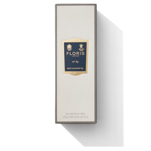 Bottle of Floris London No 80 Bath & Shower Gel filled with golden shower gel, featuring royal warrents at the top of the label embossed in gold. 