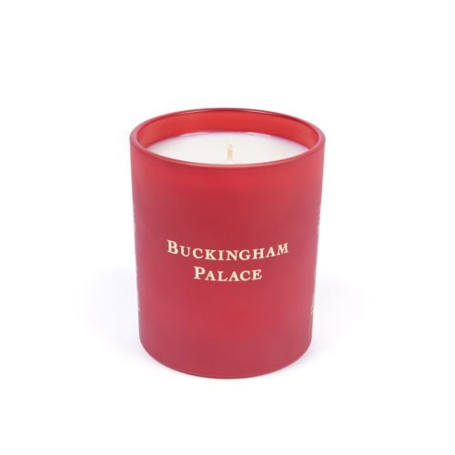 Lit red candle with Buckingham Palace Facade. 