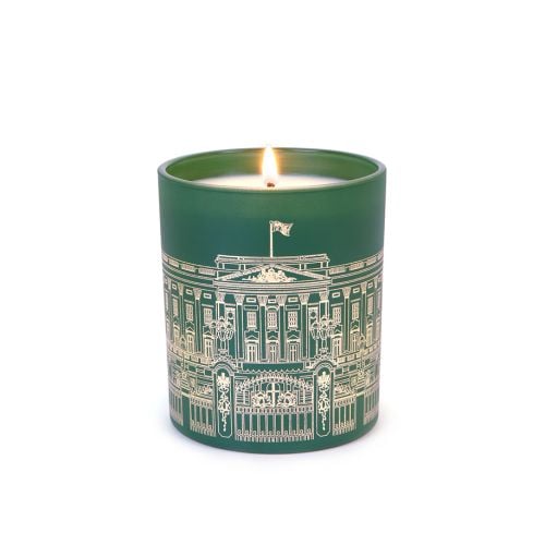 Green lit candle with Buckingham Palace Facade on front. 