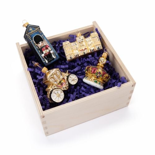 Blue sleeved box with Buckingham Palace glass baubles with Buckingham Palace facacde, golden carriage, crown and guardsman in sentry box. 