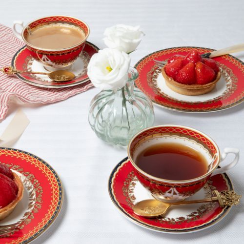 This Livey Teacup and Saucer featuring the royal coat of arms and a deep, rich scarlett edge and navy border with contrasting fine gold details, inspired by the intricate decorative braiding of hand-sewn livery and regimental devices of ceremonial uniform