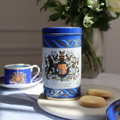 Blue and white tea caddy featuring the Royal Coat of Arms. The crest is framed with a border of thistles, roses, shamrocks and daffodils.