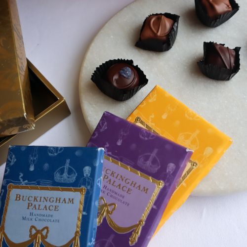 A wicker hamper featuring a chocolate box, containing handmade English Chocolate Selection, three chocolate bars and Fudge. 