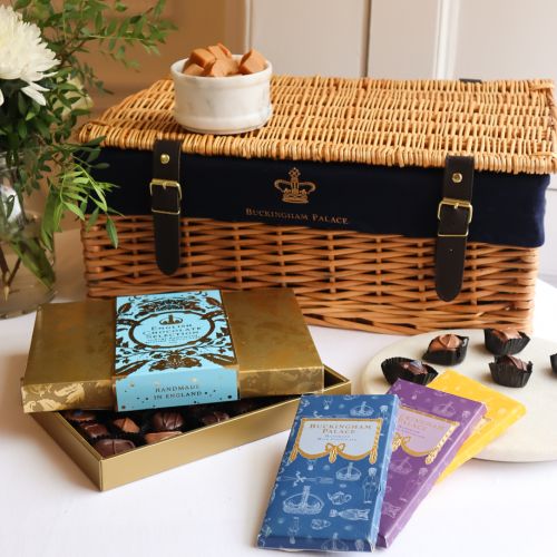 A wicker hamper featuring a chocolate box, containing handmade English Chocolate Selection, three chocolate bars and Fudge. 