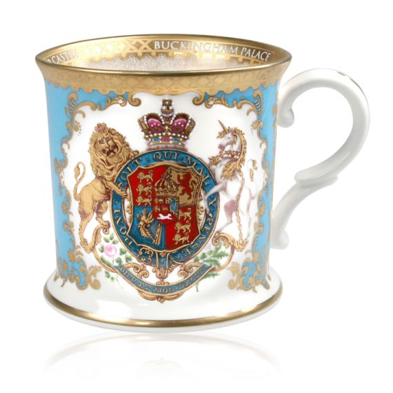 Royal coat of arms fine bone china tankard featuring a lion and unicorn royal crest surrounded by ornated gold patterns and flower patterns on a light blue coloured background. Gold plated with the words Buckingham Palace, Windsor Castle and Palace of Hol