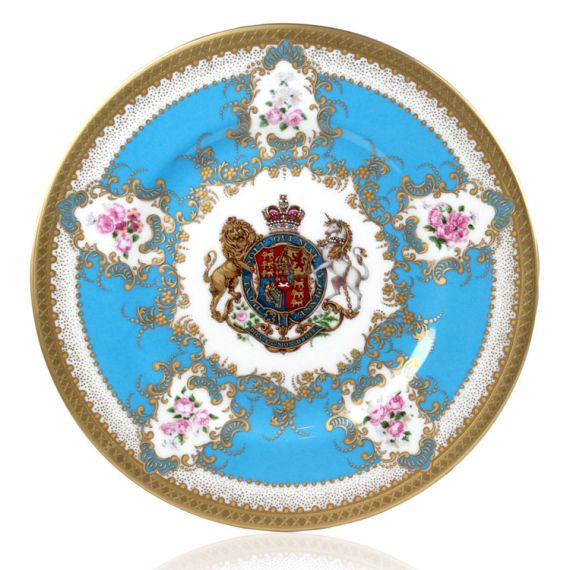 Royal coat of arms fine bone china side plate featuring a lion and unicorn royal crest surrounded by ornated gold patterns and flower patterns on a turquoise blue  background. Gold plated with the words Buckingham Palace, Windsor Castle and Palace of Holy