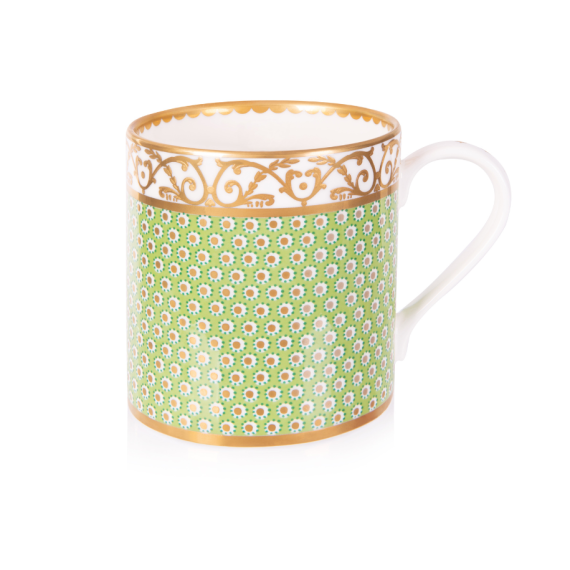 A green mug with gold detailing in a floral design and a white and gold border at the top of the mug