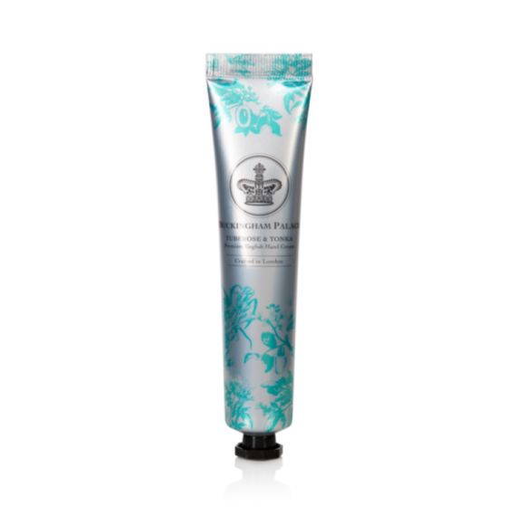 Silver tube of hand cream with a turquoise design of the ingredients. A silver crown is in the middle of the design