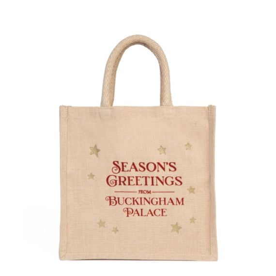 Reusable juco bag in neutral colour. Red script and gold stars decoration. 