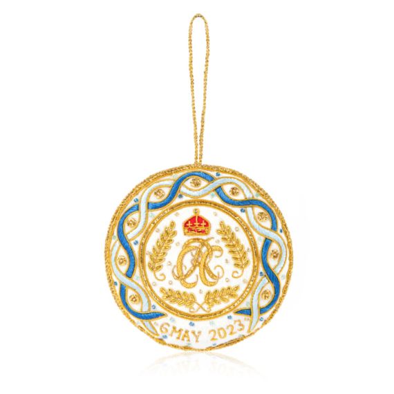 White decoration with blue and gold stitching. Joint cypher of their majesties at the centre and the date of the coronation at the bottom.