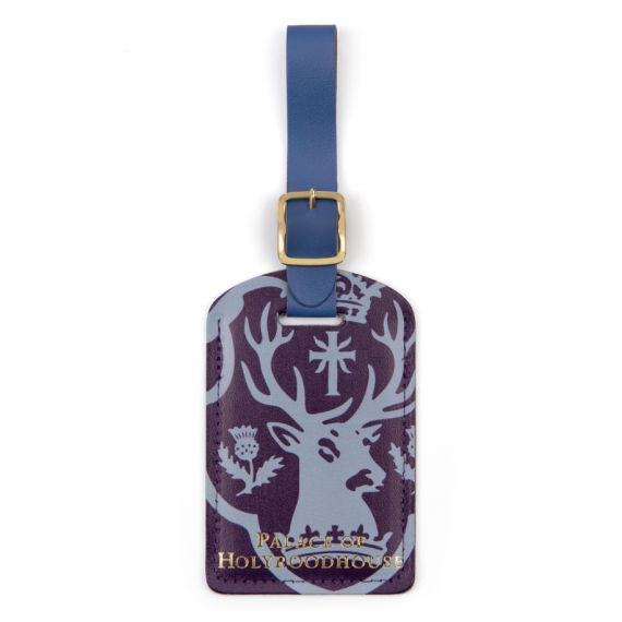 luggage tag in blue and purple, a crest of a stag and thistle illustrations and the wording palace of holyroodhouse in gold foil