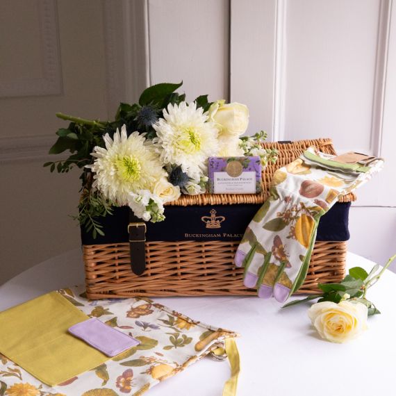 The From the Palace Garden Hamper featuring Chelsea Garden Gloves Set of 2 and Chelsea Garden Utility Belt with a botanical print featuring insects, lemons, and leaves  with green and purple detailing. Also featured is the Buckingham Palace Lavender and S