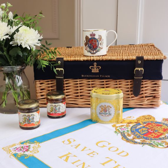 Wicker hamper with "Buckingham Palace" embossed on in gold, with  a tea towel, yellow Breakfast Tea Caddy, a jam and marmalade amd GSTK mug with Coat of Arms. 