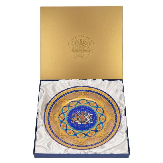 Charger plate presented in a gold box with white satin cushioning.